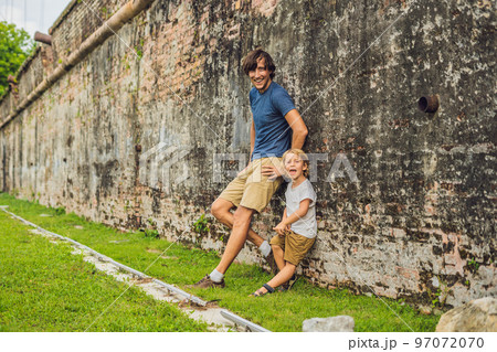 Dad and son on background of Fort Cornwallis in Georgetown, Penang, is a star fort built by the British East India Company in the late 18th century, it is the largest standing fort in Malaysia 97072070