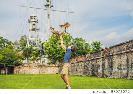 Dad and son on background of Fort Cornwallis in Georgetown, Penang, is a star fort built by the British East India Company in the late 18th century, it is the largest standing fort in Malaysia 97072079