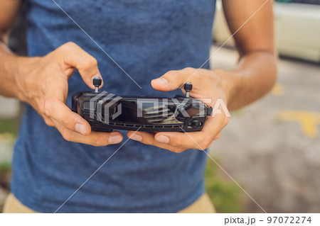 Man holds remote controller with his hands and controls the drone. New technologies and innovations concept 97072274