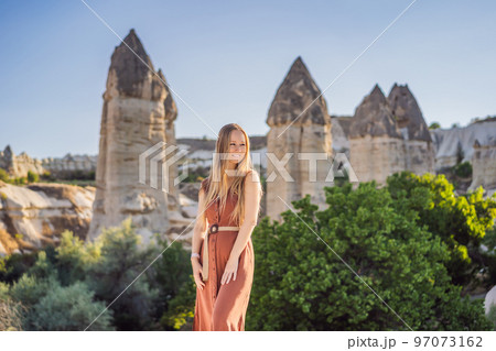 Woman tourist on background of Unique geological formations in Love Valley in Cappadocia, popular travel destination in Turkey Woman tourist on background of Unique geological formations in Love Valley in Cappadocia, popular travel destination in Turkey 97073162