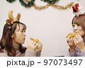 クリスマスパーティーで食事を楽しむ女子 97073497