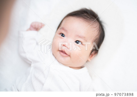 パパに見つめられて笑顔で見つめ返す生後2か月の赤ちゃん 97073898