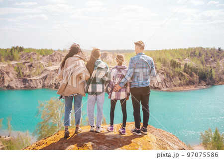 Young parents and kids hiking in mountains. Beautiful view of blue lake 97075586