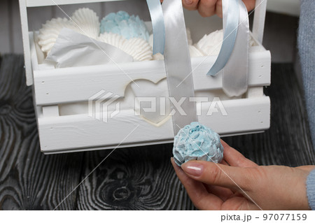 Marshmallow cones. Homemade zeohyr. The woman puts it in a wooden decorative box. On the background of the boards. Close-up. Marshmallow cones. Homemade zeohyr. The woman puts it in a wooden decorative box. On the background of the boards. Close-up. 97077159