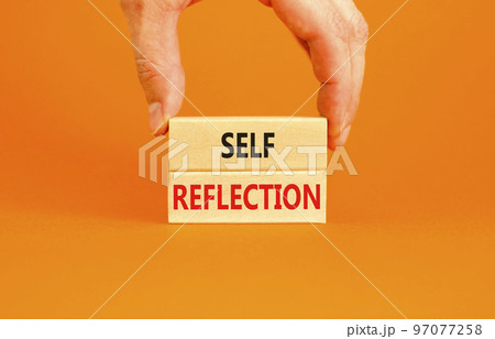 Self reflection symbol. Concept word Self reflection typed on wooden blocks. Beautiful orange table orange background. Businessman hand. Business psychological and self reflection concept. Copy space. 97077258