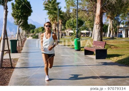 Woman jogging near beach 4k. Caucasian woman jogging in the morning near the beach in Turkey 97079334