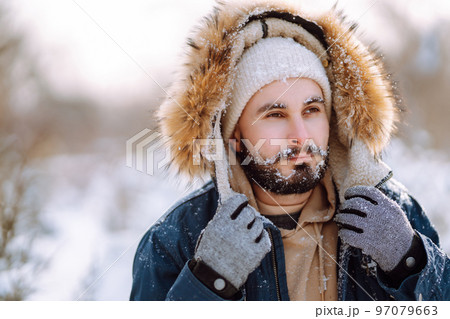 Portrait of young man in snowy winter forest. Season, christmas, travel and people concept. Portrait of young man in snowy winter forest. Season, christmas, travel and people concept. 97079663