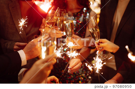 Sparkling sparklers in the hands. Playing firework to celebrate winter holidays with friends at party. 97080950