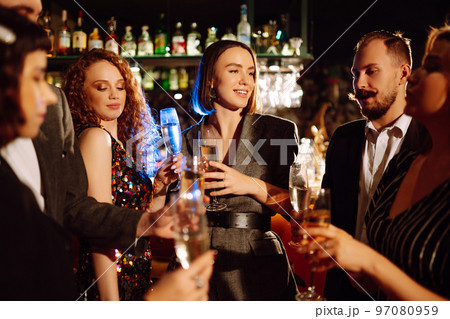 Cheering and drinking cocktails. Group of friends partying in a nightclub and toasting drinks cocktails. Cheering and drinking cocktails. Group of friends partying in a nightclub and toasting drinks cocktails. 97080959
