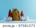Christmas or winter composition. Two gnomes with a bag of gifts in the snow. 97081373