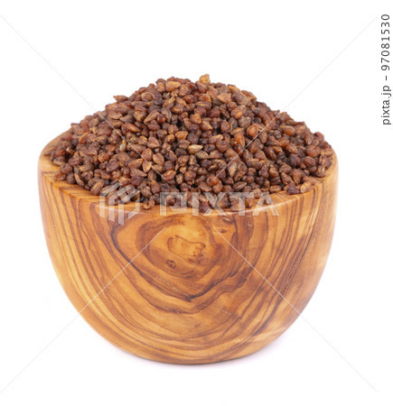 Buckwheat tea in wooden bowl, isolated on white background. Whole roasted buckwheat grains. Fagopyrum tataricum. 97081530