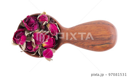 Heap of dry tea roses buds in wooden spoon, isolated on white background. Rose flower tea. Phnom Penh rose tea. Clipping path. Top view. 97081531