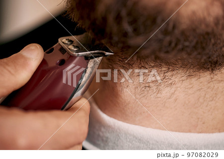 Barber shaving caucasian man in barber shop 97082029