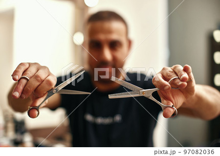 barber hand testing the sharpness of blade 97082036
