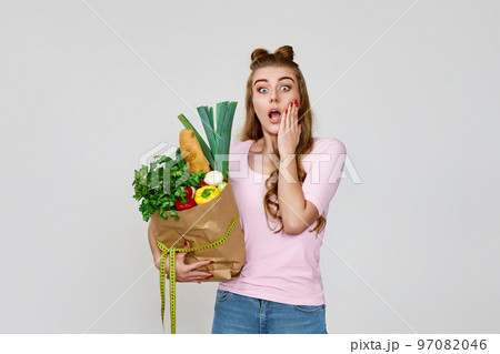 surprised caucasian vegetarian woman hold paper bag with groceries 97082046