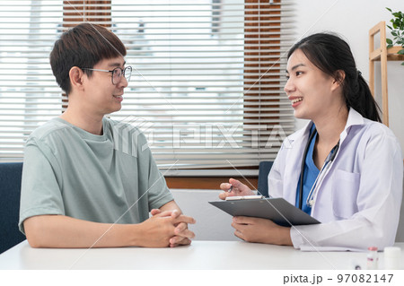 Female doctor physician is taking notes on clipboard and writing prescription while asking symptom Female doctor physician is taking notes on clipboard and writing prescription while asking symptom 97082147