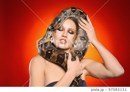 Beautiful woman with boa constrictor on bright colorful background Beautiful woman with boa constrictor on bright colorful background 97083131