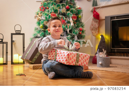 Boy opening christmas present 97083254