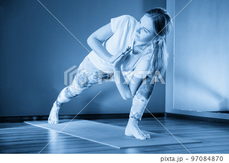 Young attractive woman does yoga exercise in the gym on mat 97084870