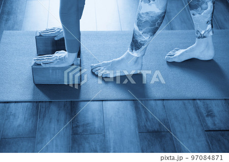Women practicing yoga stretching using wooden blocks with hands, exercise for spine and shoulders flexibility 97084871
