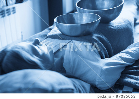 Tibetan singing bowls in sound therapy in spa center over a woman body 97085055