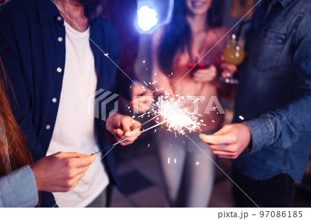 Group of friends having fun with sparklers. young people laugh. celebrating New Year together. Group of friends having fun with sparklers. young people laugh. celebrating New Year together. 97086185
