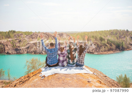 Young parents and kids on picnic after hiking in mountains. Beautiful view of blue lake 97087990