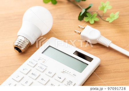 机に置かれた電卓とコンセントプラグ　木目バック 97091728