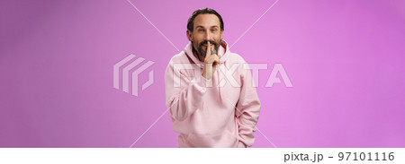 Lips sealed secret. Portrait alluring cheeky stylish adult bearded guy in pink hoodie asking keep quiet show shush shh gesture index finger pressed mouth smiling devious smug face, have idea 97101116
