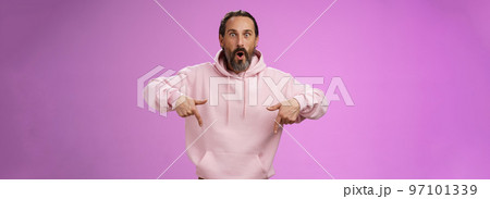Impressed fascinated speechless dad bearded grey hair say wow widen eyes surprised folding lips amused curiously pointing down index fingers see super amazing advertisement, posing purple background Impressed fascinated speechless dad bearded grey hair say wow widen eyes surprised folding lips amused curiously pointing down index fingers see super amazing advertisement, posing purple background 97101339