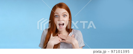 Amused happy grateful european redhead woman gasping drop jaw joyfully press palms chest thankful staring surprised incredible cool gift receive awesome proposal standing blue background 97101395
