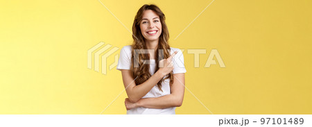 Cheerful charismatic good-looking gentle girl laughing silly amused entertaining conversation pointing upper left corner inviting check out try delicious coffee smiling broadly yellow background 97101489