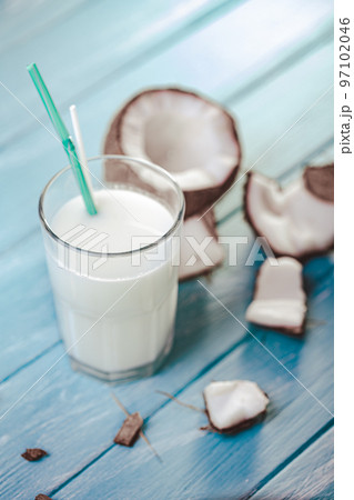 Top view of coconut cocktail in glass with coconut on white wooden table. Selective focus. Tropical 97102046