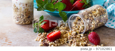 Homemade summer healthy breakfast. Greek yogurt with granola, pieces fresh strawberry on stone table. Banner. Homemade summer healthy breakfast. Greek yogurt with granola, pieces fresh strawberry on stone table. Banner. 97102861