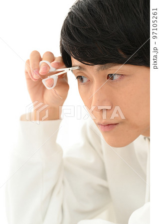 自分で眉毛を整える若い男性 97105261