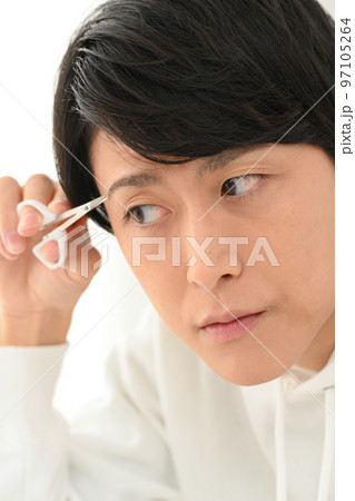 自分で眉毛を整える若い男性 97105264