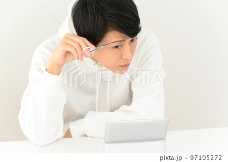 自分で眉毛を整える若い男性 97105272