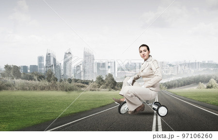 Beautiful young woman riding children's bicycle Beautiful young woman riding children's bicycle 97106260