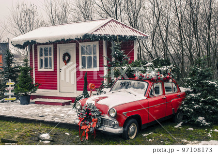 Decorated Santa's house with a red vintage car in 97108173