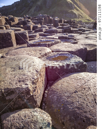 A few of the 40000 interlocking basalt columns at the Giant's Causeway by Bushmills in Northern Ireland, United Kingdom A few of the 40000 interlocking basalt columns at the Giant's Causeway by Bushmills in Northern Ireland, United Kingdom 97111198