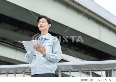 タブレットを持つ作業服の男性 97115151