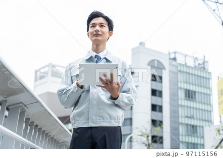 タブレットを持つ作業服の男性 97115156