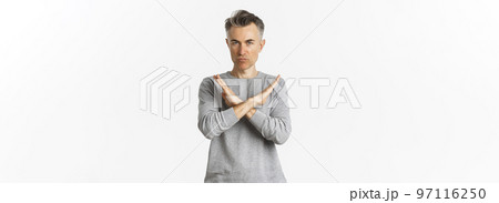 Image of angry middle-aged man looking serious, making cross gesture to stop something bad, telling no, prohibit action, standing over white background 97116250