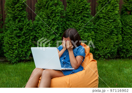 girl with a laptop in the garden 97116902