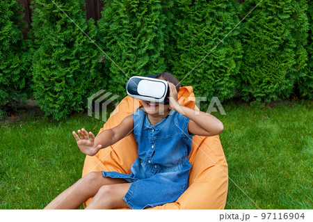 Girl with virtual reality glasses in the park Girl with virtual reality glasses in the park 97116904
