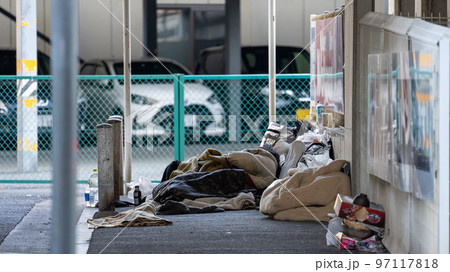 道路でうずくまるホームレス 97117818