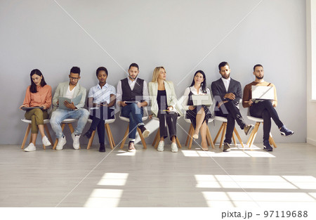Group of different multiethnic people sitting in row in waiting room before interview or meeting. 97119688