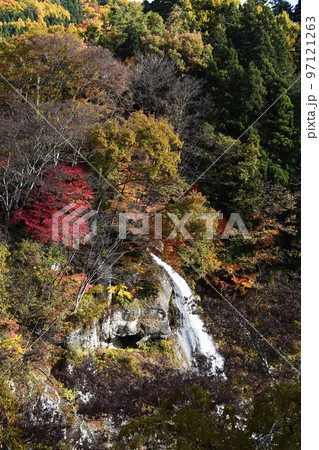 紅葉の渓谷に流れる美しい滝が見える風景（縦構図遠景） 97121263