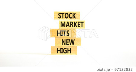 Stock market hits new high symbol. Concept words Stock market hits new high on wooden blocks on a beautiful white table white background. Business and stock market hits new high concept. Copy space. Stock market hits new high symbol. Concept words Stock market hits new high on wooden blocks on a beautiful white table white background. Business and stock market hits new high concept. Copy space. 97122832