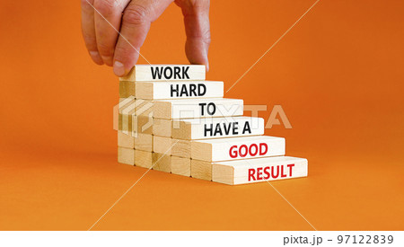 Work hard for result symbol. Concept words Work hard to have a good result on wooden blocks on a beautiful orange table orange background. Businessman hand. Business work hard for good result concept. 97122839